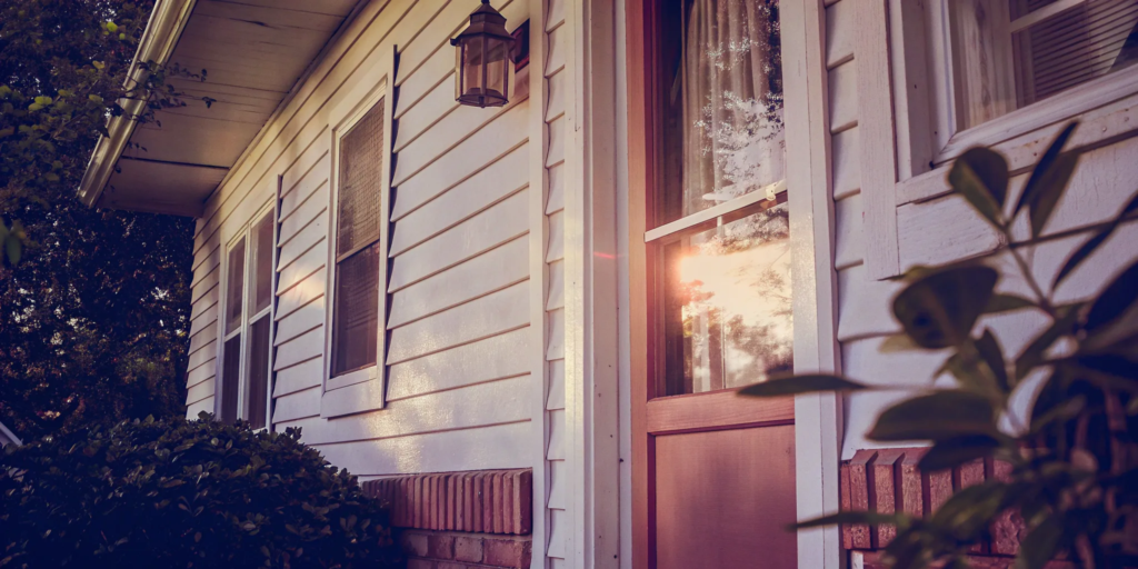 Selling a distressed property with a weathered porch and overgrown bushes.