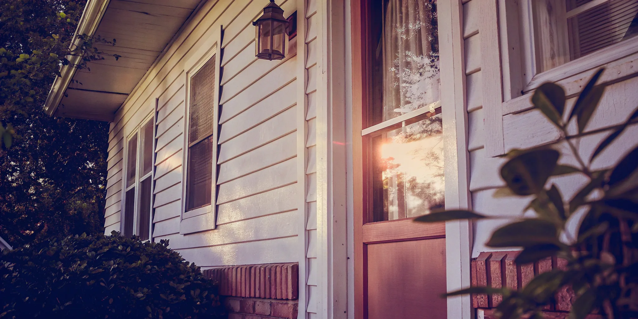 Selling a distressed property with a weathered porch and overgrown bushes.