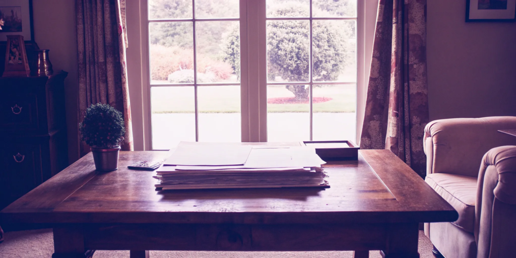 Paperwork on a wooden table for calculating capital gains tax after selling inherited property.