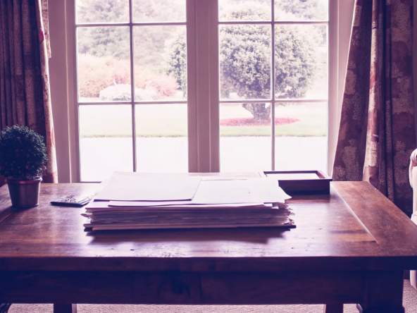 Paperwork on a wooden table for calculating capital gains tax after selling inherited property.
