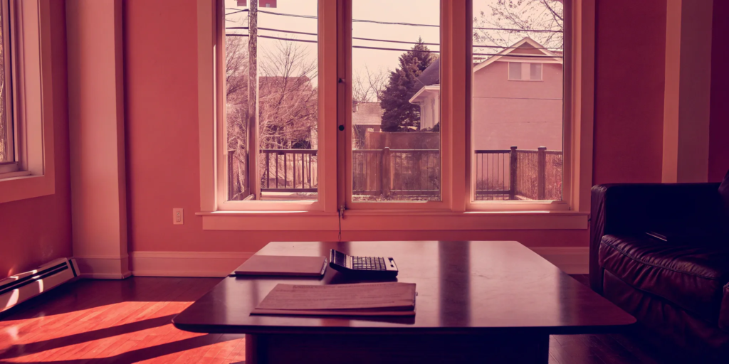 A calculator and documents on a coffee table for negotiating sellers paying buyers agent commission.