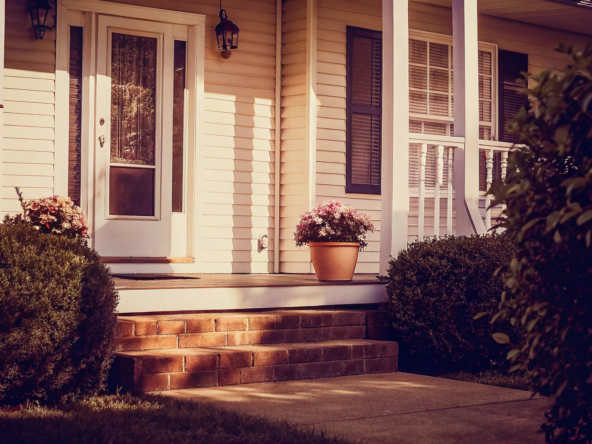 Front porch of an inherited house with flowers, prepared to sell.