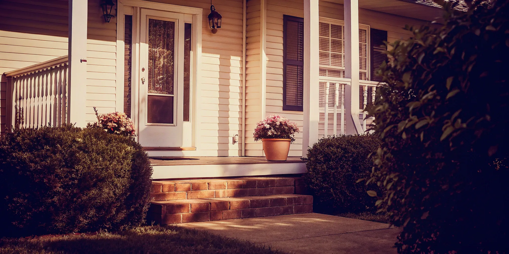 Front porch of an inherited house with flowers, prepared to sell.