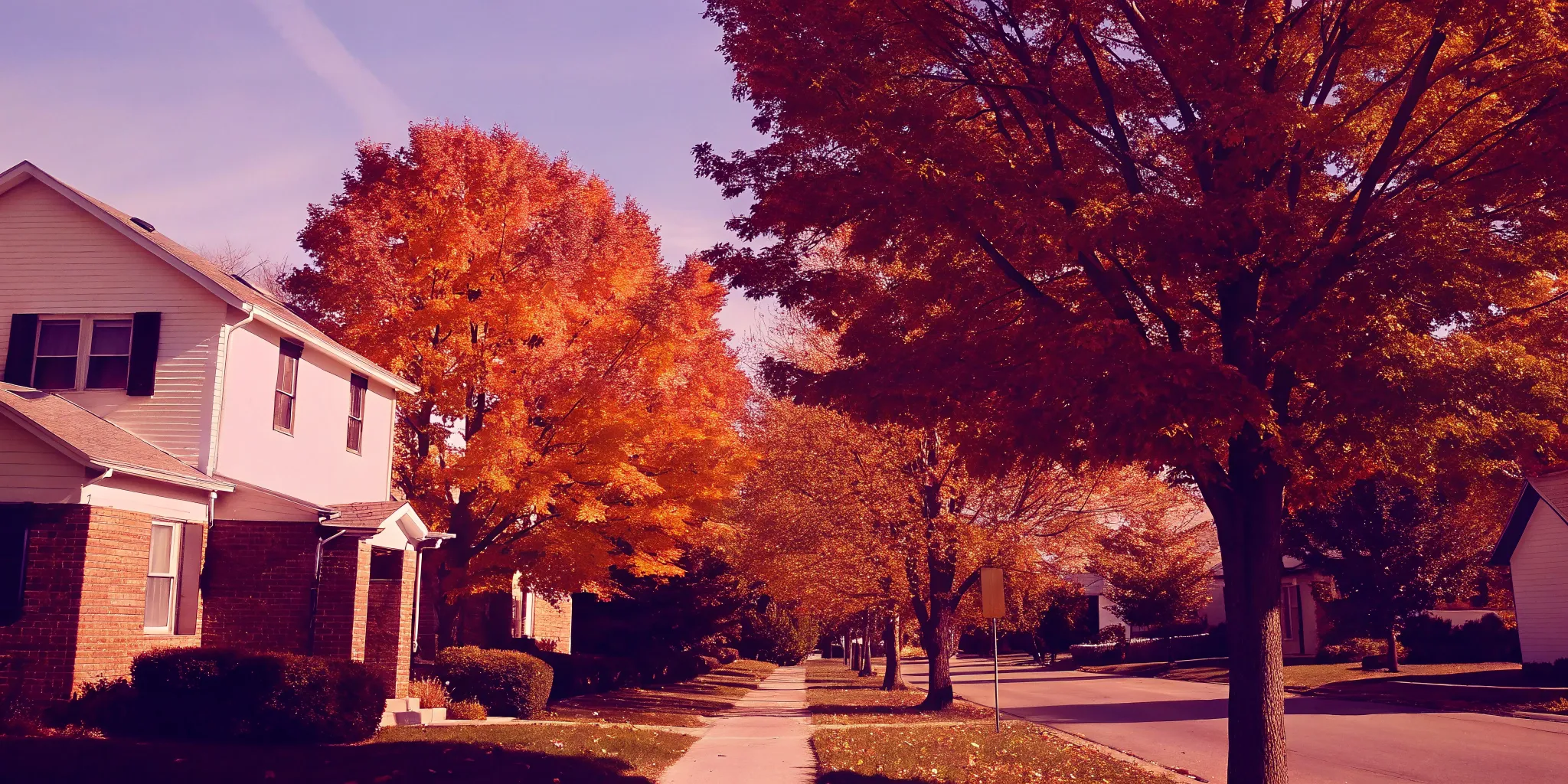 A suburban home on an autumn street, weighing the pros and cons of selling a house as is.