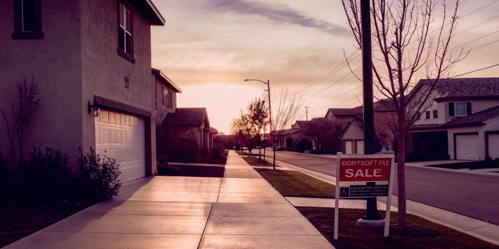A for sale sign in front of a house at sunset, the best way for a quick sale.