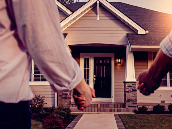 Couple holding hands in front of their new home, discussing closing costs for a private sale.