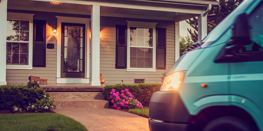 A quick sale house buyer's van parked in the driveway of a suburban home.