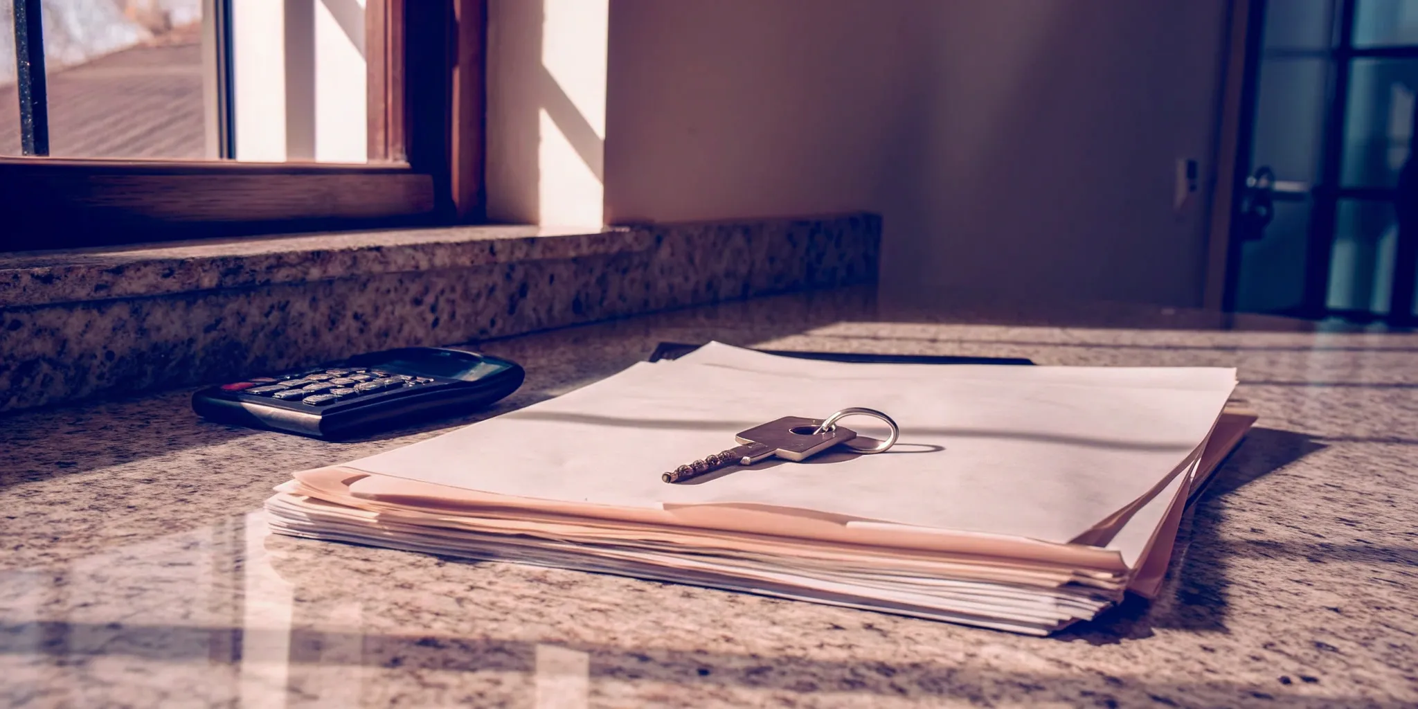 House key next to documents outlining who pays closing costs in a cash sale.