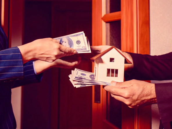 A person exchanges a house model for a stack of cash in an instant cash for home sale.
