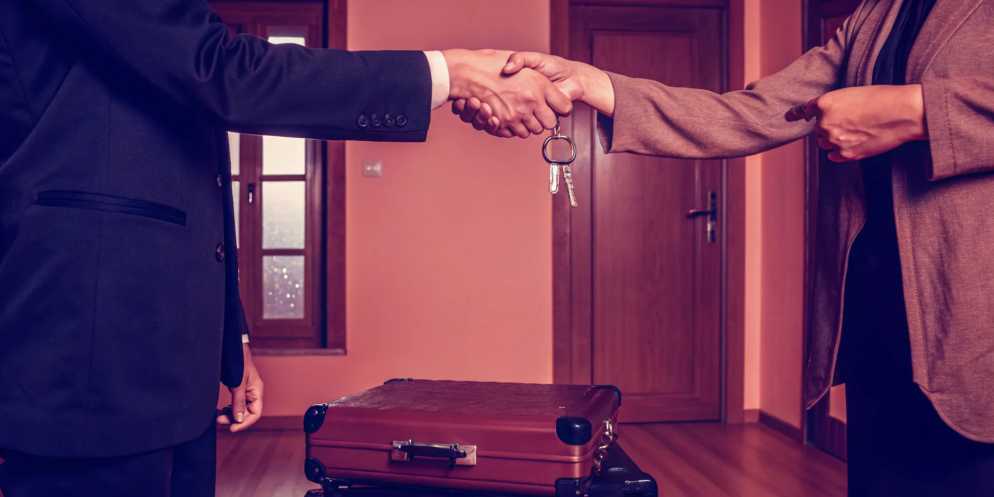 Handshake over house keys and a briefcase for a quick sale due to a job move.